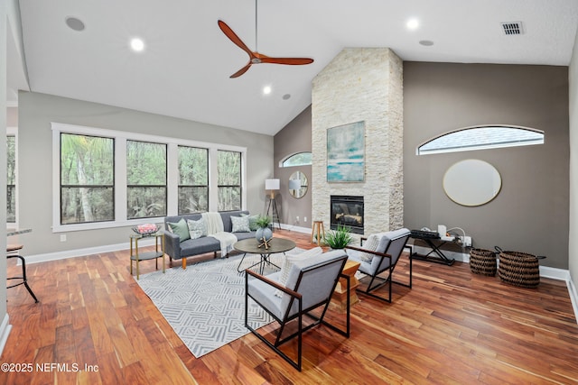725 Carthage Pl, Saint Johns, FL 32259 - living area with ceiling fan, a stone fireplace, light wood-style flooring, baseboards, and high vaulted ceiling