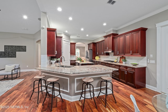 725 Carthage Pl, Saint Johns, FL 32259 - kitchen featuring arched walkways, a sink, reddish brown cabinets, stainless steel appliances, and recessed lighting