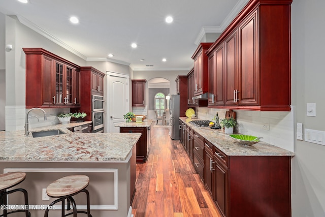 725 Carthage Pl, Saint Johns, FL 32259 - kitchen with a sink, arched walkways, dark brown cabinets, stainless steel appliances, and a peninsula