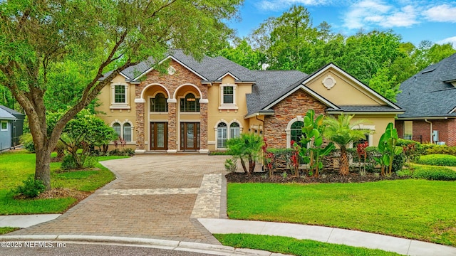 725 Carthage Pl, Saint Johns, FL 32259 - view of front of property with stucco siding, driveway, stone siding, a front lawn, and a shingled roof