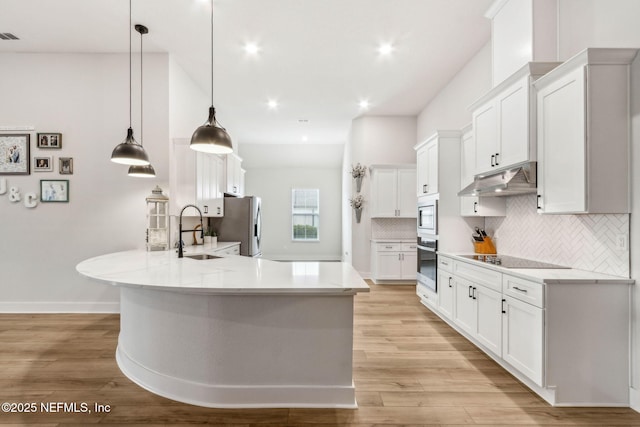 36039 Pitch Ln, Hilliard, FL 32046 - kitchen featuring stainless steel appliances, under cabinet range hood, a sink, a peninsula, and decorative backsplash