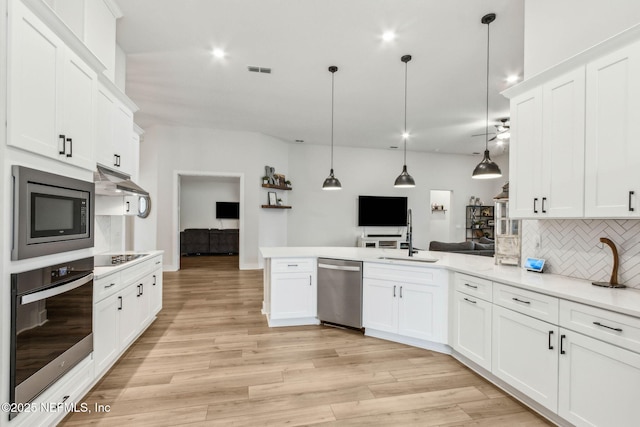 36039 Pitch Ln, Hilliard, FL 32046 - kitchen featuring appliances with stainless steel finishes, a peninsula, a sink, backsplash, and light countertops