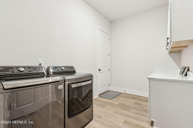 36039 Pitch Ln, Hilliard, FL 32046 - laundry room featuring cabinet space, separate washer and dryer, light wood-style floors, and baseboards