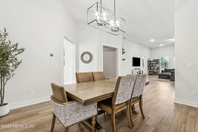 36039 Pitch Ln, Hilliard, FL 32046 - dining area featuring light wood-style floors, a chandelier, baseboards, and a high ceiling