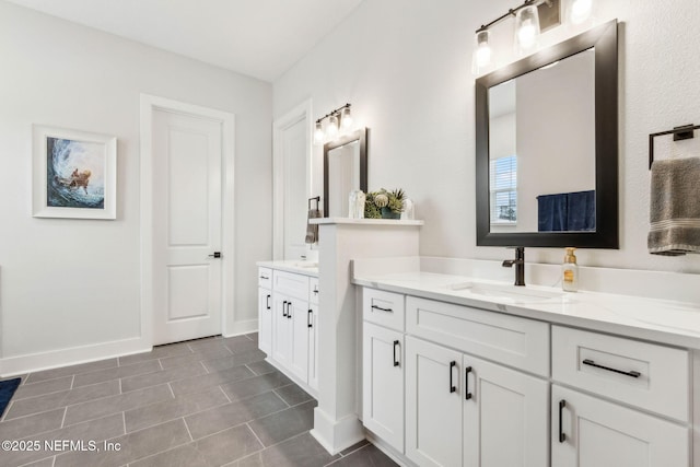 36039 Pitch Ln, Hilliard, FL 32046 - bathroom with two vanities, baseboards, and tile patterned floors