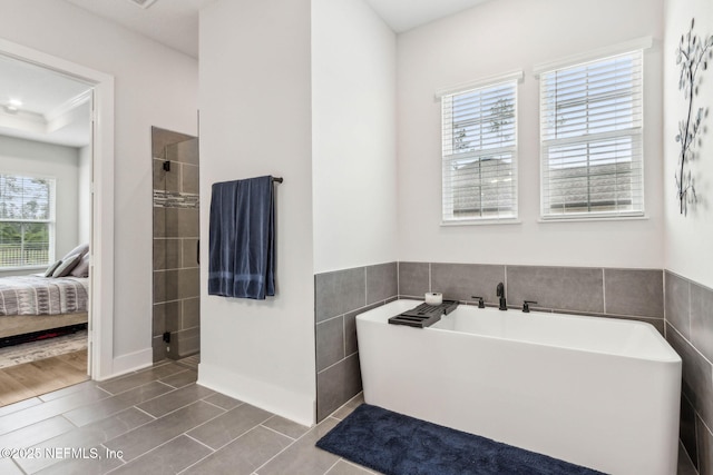 36039 Pitch Ln, Hilliard, FL 32046 - bathroom featuring tile patterned floors, a soaking tub, ensuite bathroom, a tile shower, and tile walls