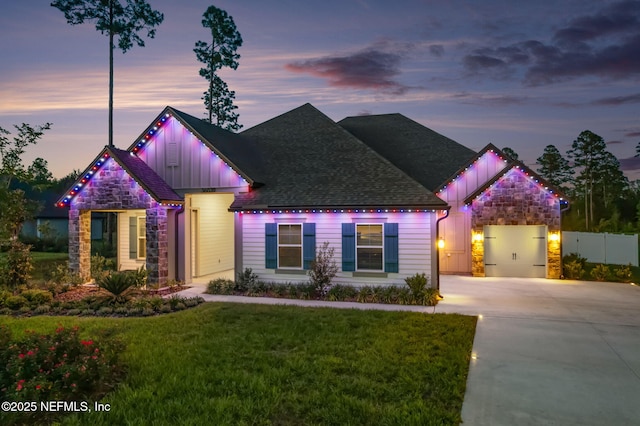 36039 Pitch Ln, Hilliard, FL 32046 - view of front facade with board and batten siding, stone siding, driveway, a lawn, and roof with shingles
