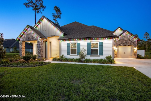 36039 Pitch Ln, Hilliard, FL 32046 - view of front of home with stone siding, board and batten siding, driveway, a front yard, and an attached garage