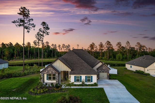 36039 Pitch Ln, Hilliard, FL 32046 - view of front of home with board and batten siding, driveway, a front yard, stone siding, and a water view