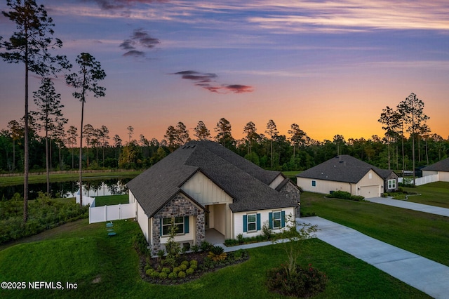 36039 Pitch Ln, Hilliard, FL 32046 - ranch-style house featuring stone siding, board and batten siding, a water view, a shingled roof, and concrete driveway