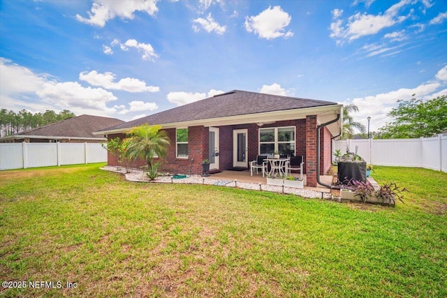 back of property with a lawn, a patio, a fenced backyard, and brick siding
