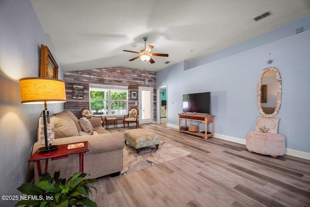 living room featuring visible vents, wood finished floors, lofted ceiling, baseboards, and ceiling fan
