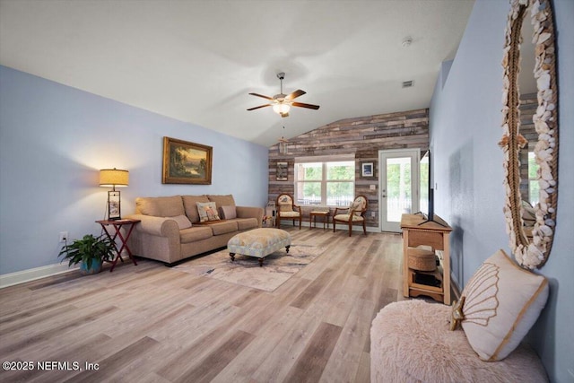 living room with a ceiling fan, visible vents, wood finished floors, baseboards, and lofted ceiling