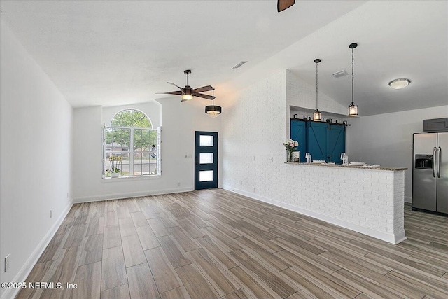 12322 Mastin Cove Rd, Jacksonville, FL 32225 - unfurnished living room with ceiling fan, vaulted ceiling, wood finished floors, and baseboards