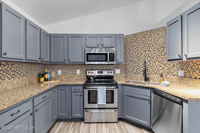 12322 Mastin Cove Rd, Jacksonville, FL 32225 - kitchen featuring stainless steel appliances, a sink, lofted ceiling, gray cabinets, and backsplash