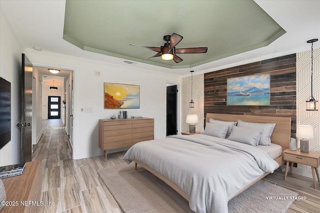 12322 Mastin Cove Rd, Jacksonville, FL 32225 - bedroom featuring a tray ceiling, wood walls, ceiling fan, and light wood finished floors