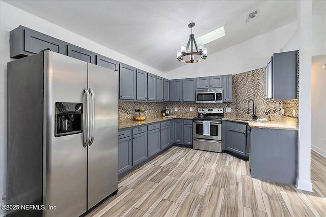 12322 Mastin Cove Rd, Jacksonville, FL 32225 - kitchen featuring stainless steel appliances, a chandelier, tasteful backsplash, a sink, and lofted ceiling