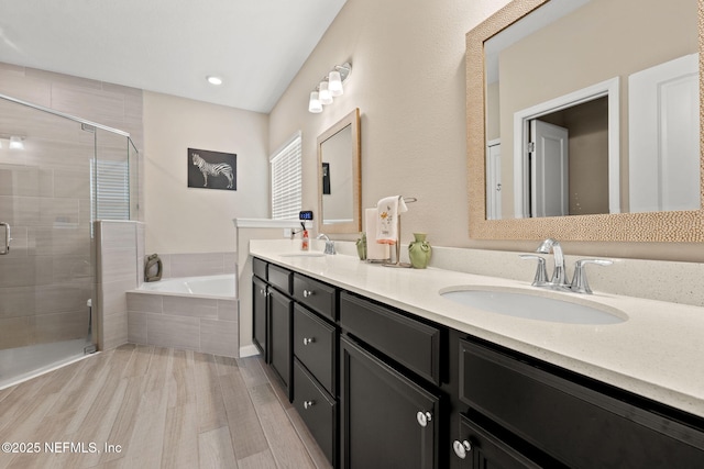 bathroom featuring a sink, a garden tub, a stall shower, and wood finished floors