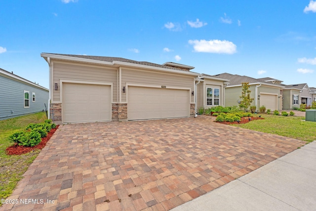 prairie-style house featuring a garage and decorative driveway