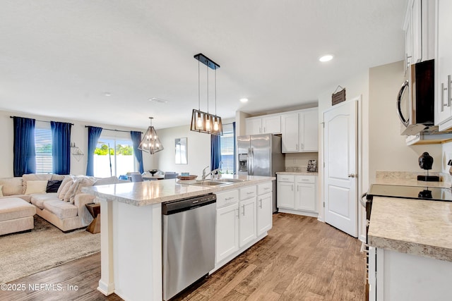 2471 Cold Stream Ln, Green Cove Springs, FL 32043 - kitchen featuring appliances with stainless steel finishes, open floor plan, light countertops, light wood-style floors, and white cabinetry
