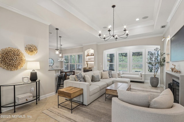 90 Kenmore Ave, Ponte Vedra, FL 32081 - tiled living area featuring a chandelier, ornamental molding, a tray ceiling, baseboards, and a glass covered fireplace