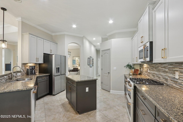 90 Kenmore Ave, Ponte Vedra, FL 32081 - kitchen featuring appliances with stainless steel finishes, arched walkways, a sink, tasteful backsplash, and stone countertops