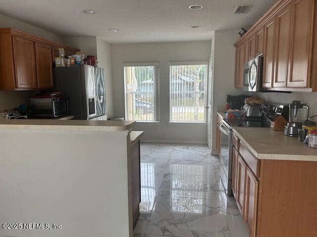 kitchen with marble finish floor, light countertops, visible vents, and appliances with stainless steel finishes