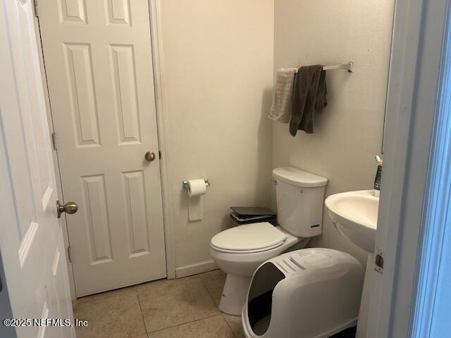 bathroom featuring toilet and tile patterned floors