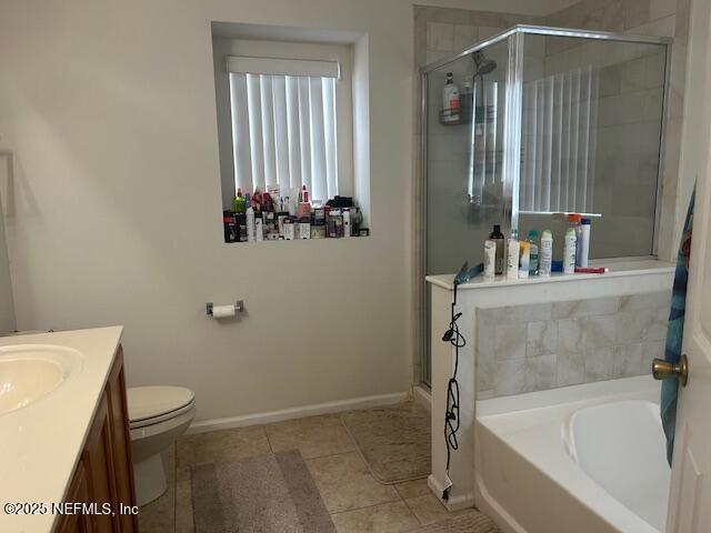 bathroom featuring a garden tub, a stall shower, baseboards, tile patterned flooring, and vanity