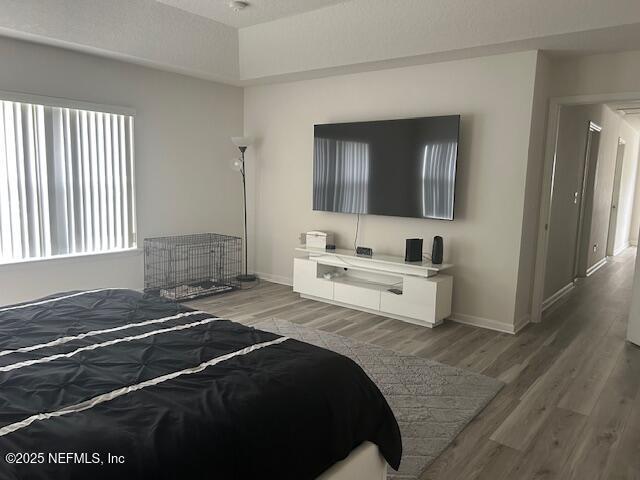 bedroom with light wood-style flooring and baseboards
