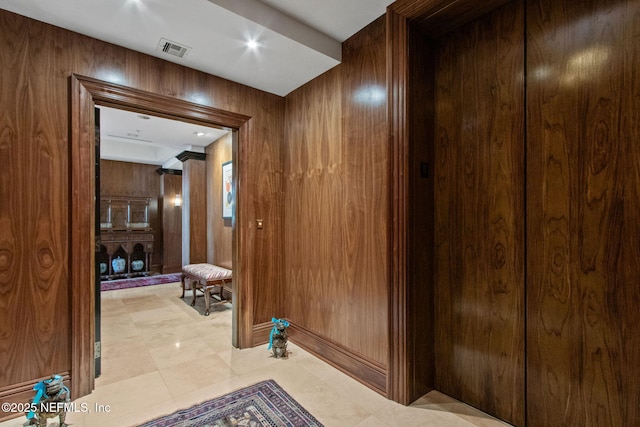 hallway featuring wooden walls