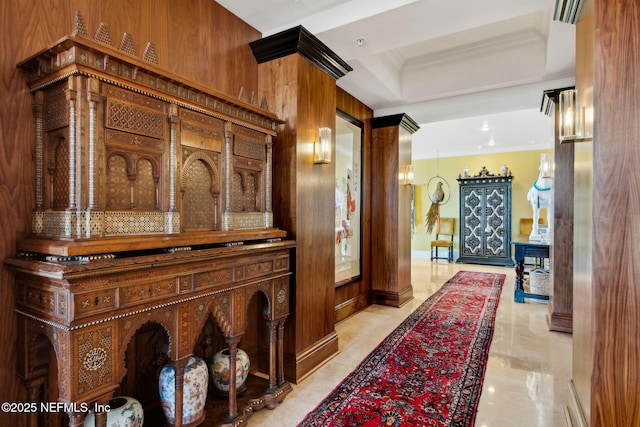 hallway with crown molding and light marble finish flooring