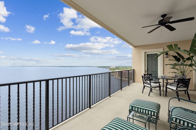 balcony featuring ceiling fan and a water view