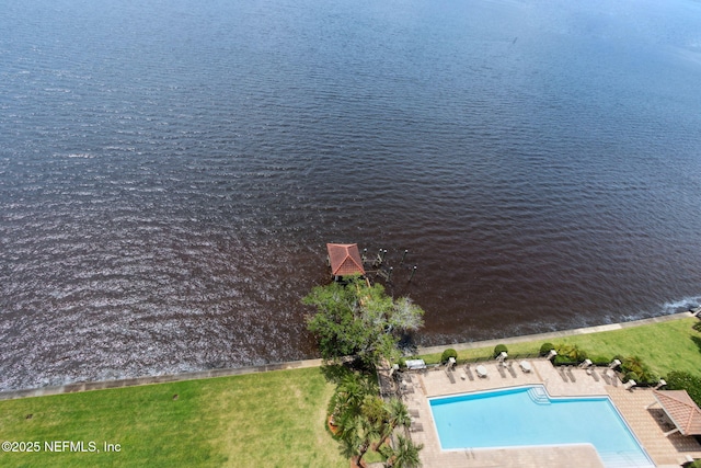 aerial view of a pool area and a nearby body of water