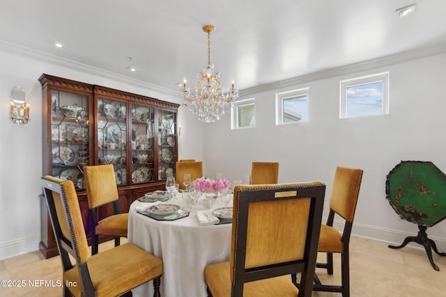 dining space with a chandelier, ornamental molding, and baseboards
