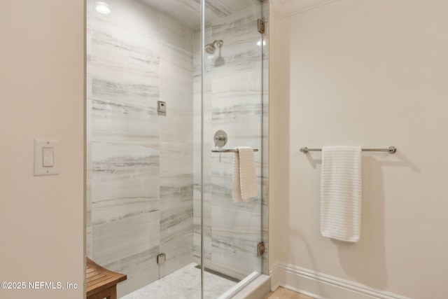 full bathroom featuring a shower stall and baseboards