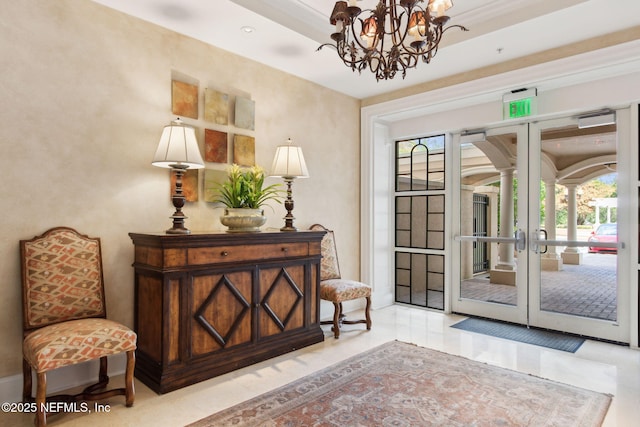 doorway with plenty of natural light, a chandelier, and ornate columns