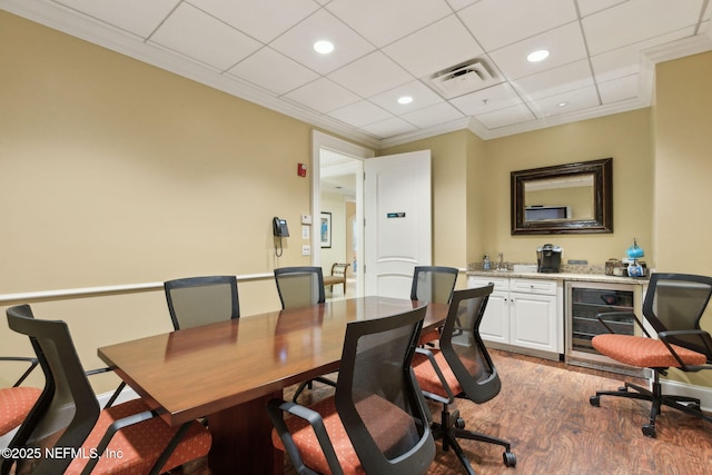 home office featuring wet bar, beverage cooler, wood finished floors, recessed lighting, and a paneled ceiling