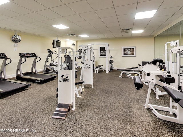 workout area featuring a paneled ceiling and baseboards