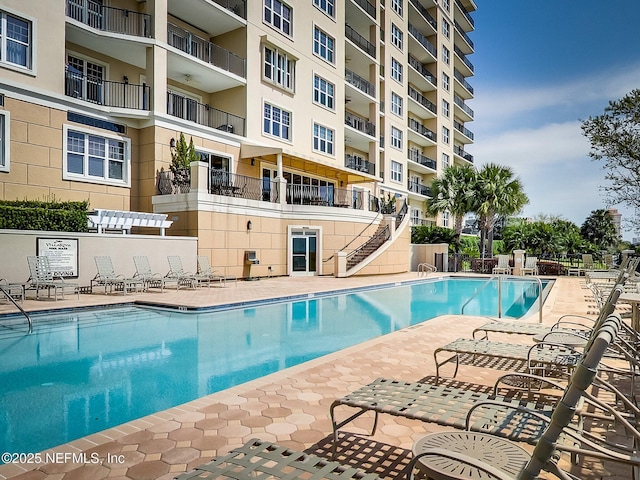 community pool featuring a patio and fence