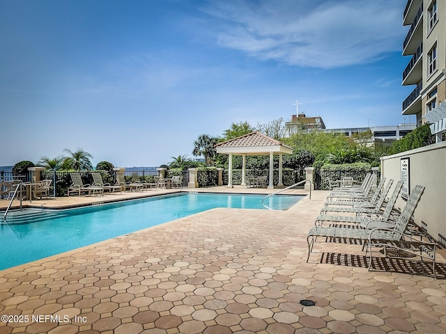 community pool with a gazebo, a patio area, and fence