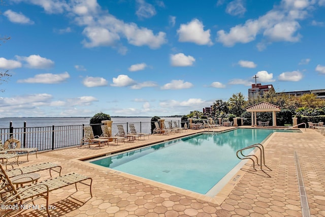 community pool with a gazebo, a patio, a water view, and fence