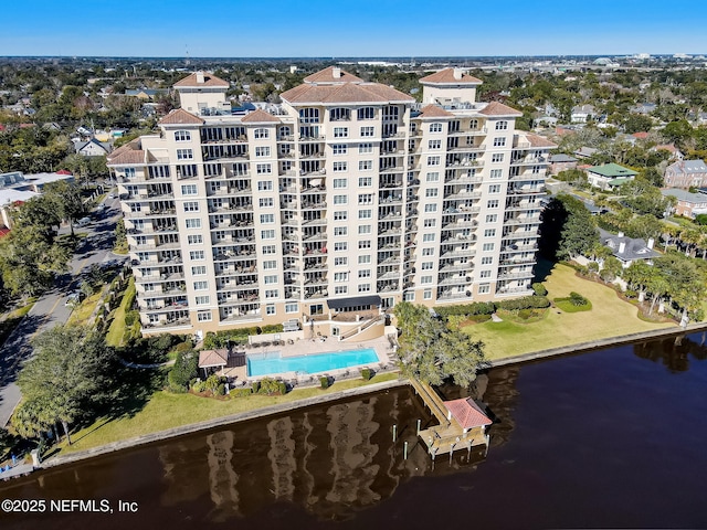 aerial view of property and surrounding area with apartment complex, a large body of water, and a pool