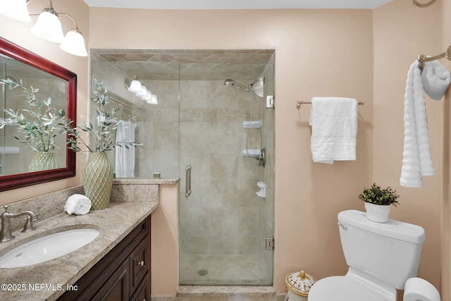 full bathroom featuring vanity, a shower stall, and toilet