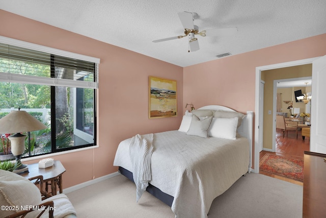 bedroom with a textured ceiling, baseboards, and ceiling fan