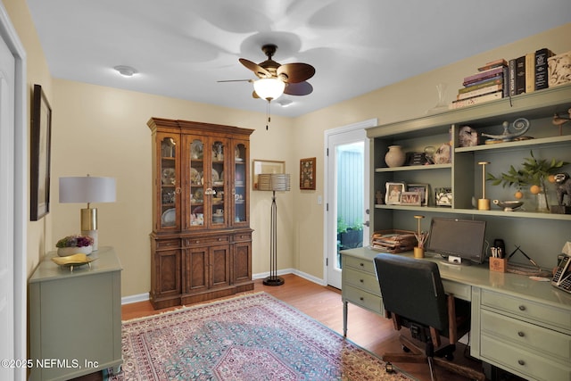 home office with ceiling fan, wood finished floors, built in study area, and baseboards