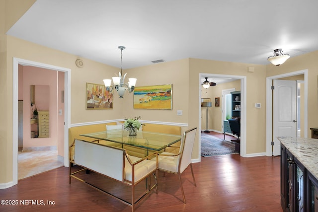 dining room featuring a chandelier, dark wood finished floors, and baseboards