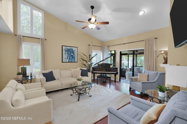 living area with wood finished floors, a ceiling fan, and high vaulted ceiling