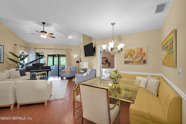 dining space featuring wood finished floors, a chandelier, and a ceiling fan