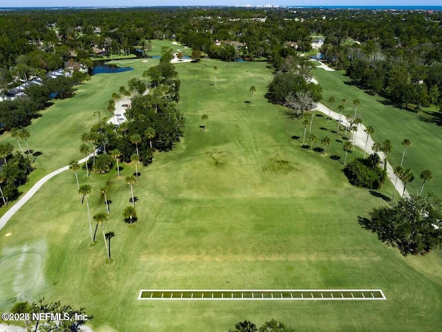 aerial view of property's location with a large body of water, a golf course, and a tree filled landscape